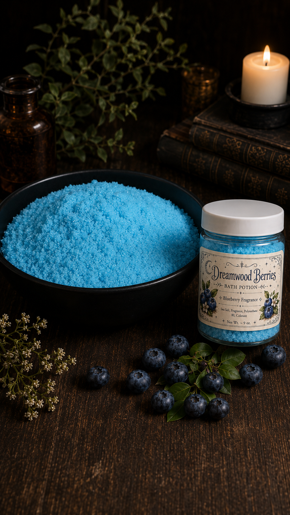 Dreamwood Berries Bath Potion jar beside blue bath salts, blueberries, greenery, candle and old books.